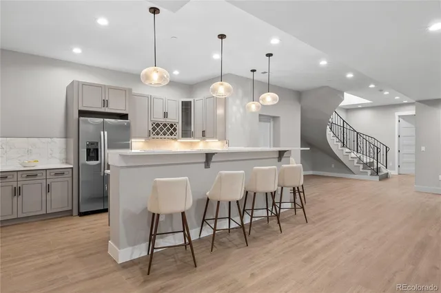 a kitchen with a dining table chairs wooden floor cabinets and stainless steel appliances
