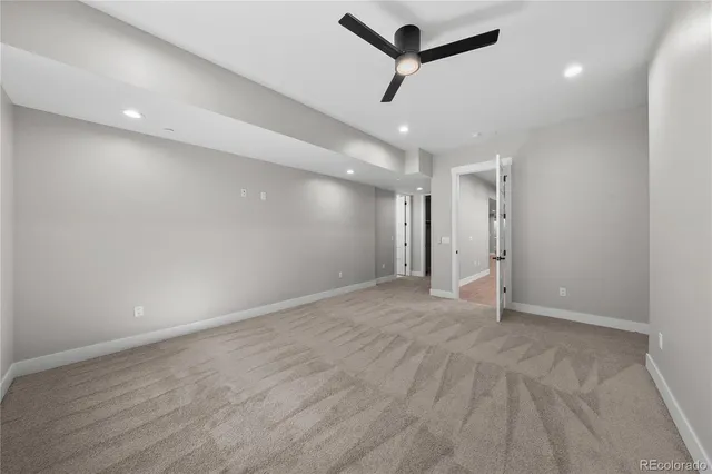 an empty room with ceiling fan and window
