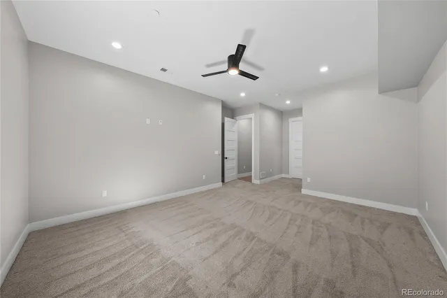 an empty room with ceiling fan and window