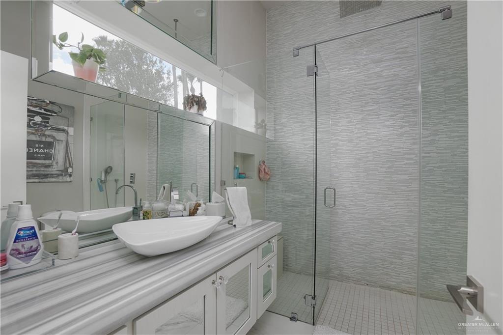 1500 Coffee Port Road Brownsville, TX 78521 - Photo 17 of 42 a bathroom with a granite countertop sink a mirror and shower