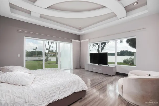 a bedroom with a bed and large windows