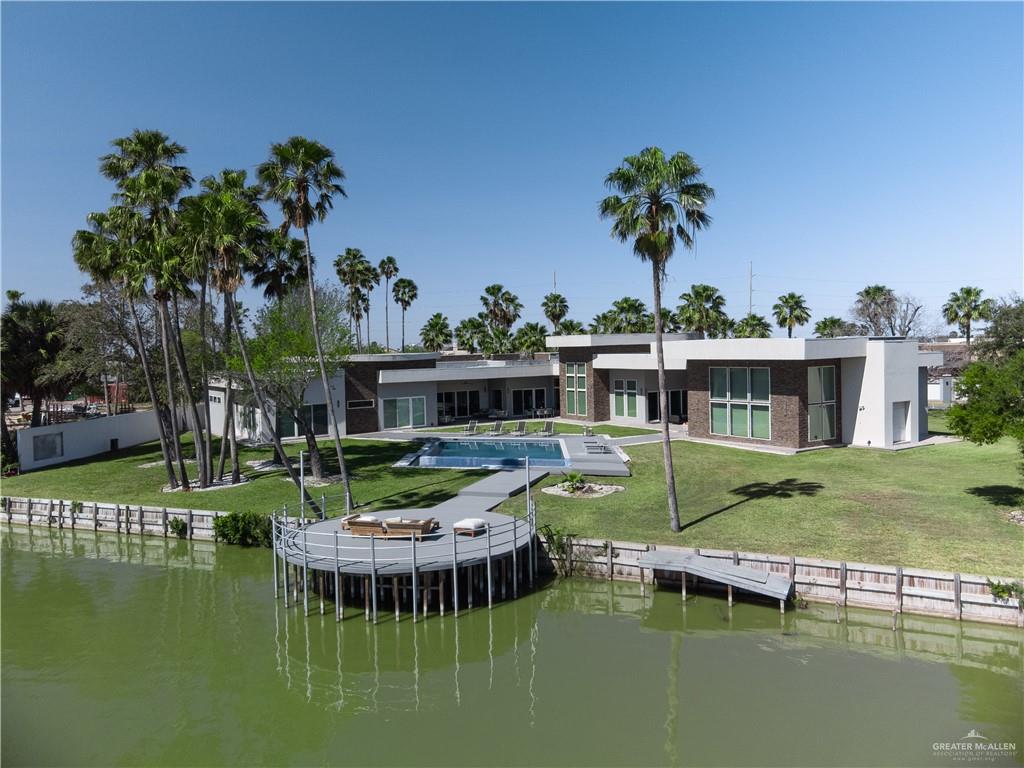 1500 Coffee Port Road Brownsville, TX 78521 - Photo 2 of 42 a front view of a house with swimming pool having outdoor seating