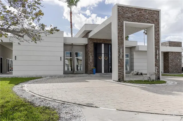 a view of a white house with a sink and a yard