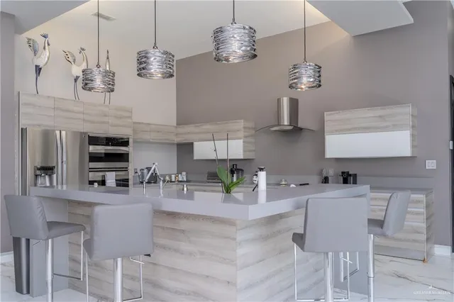 a kitchen with stainless steel appliances granite countertop a sink and a chandelier
