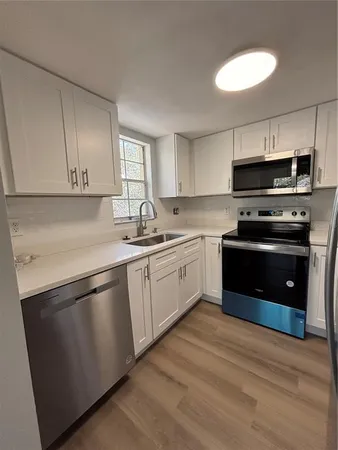 a kitchen with stainless steel appliances granite countertop a stove a sink and a microwave