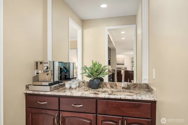 a bathroom with a granite countertop sink and a mirror
