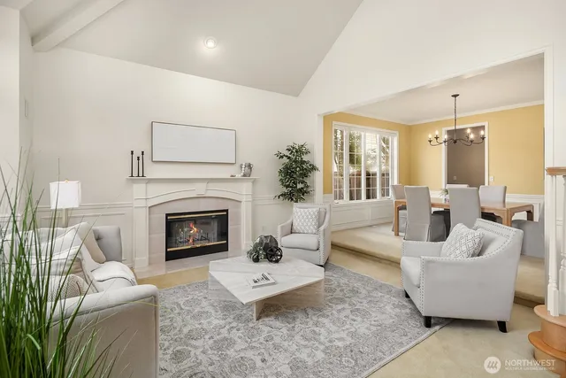 a living room with furniture fireplace and a large window