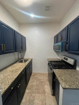 a kitchen with a stove sink and cabinets