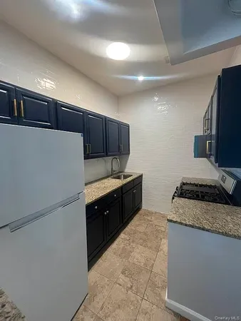 a kitchen with stainless steel appliances granite countertop a refrigerator stove a sink and a oven