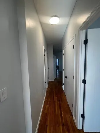 a view of a hallway with wooden floor and staircase