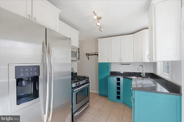 a kitchen with stainless steel appliances granite countertop a refrigerator and a stove