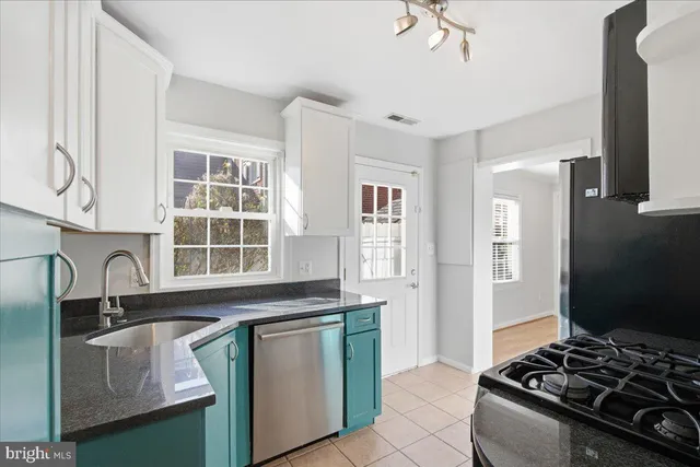 a kitchen with granite countertop a stove and a sink