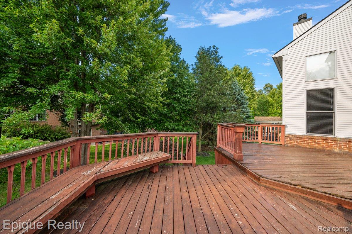 1909 Catlin Drive Rochester, MI 48306 - Photo 63 of 76 Multi-level wood deck featuring integrated seating and surrounding mature trees