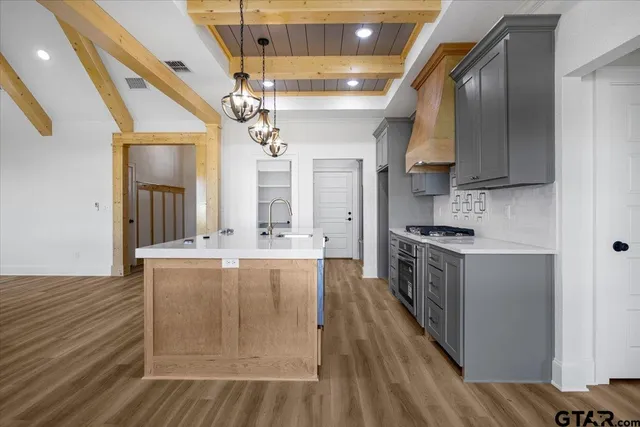 a kitchen with stainless steel appliances granite countertop a stove and a wooden floors