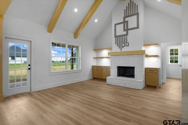 a view of a hallway with wooden floor and closet