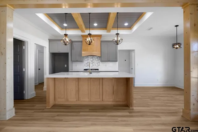 an open kitchen with a sink and dishwasher with white cabinets