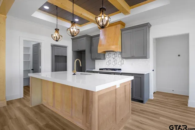 a large kitchen with kitchen island a large counter space a sink stainless steel appliances and cabinets