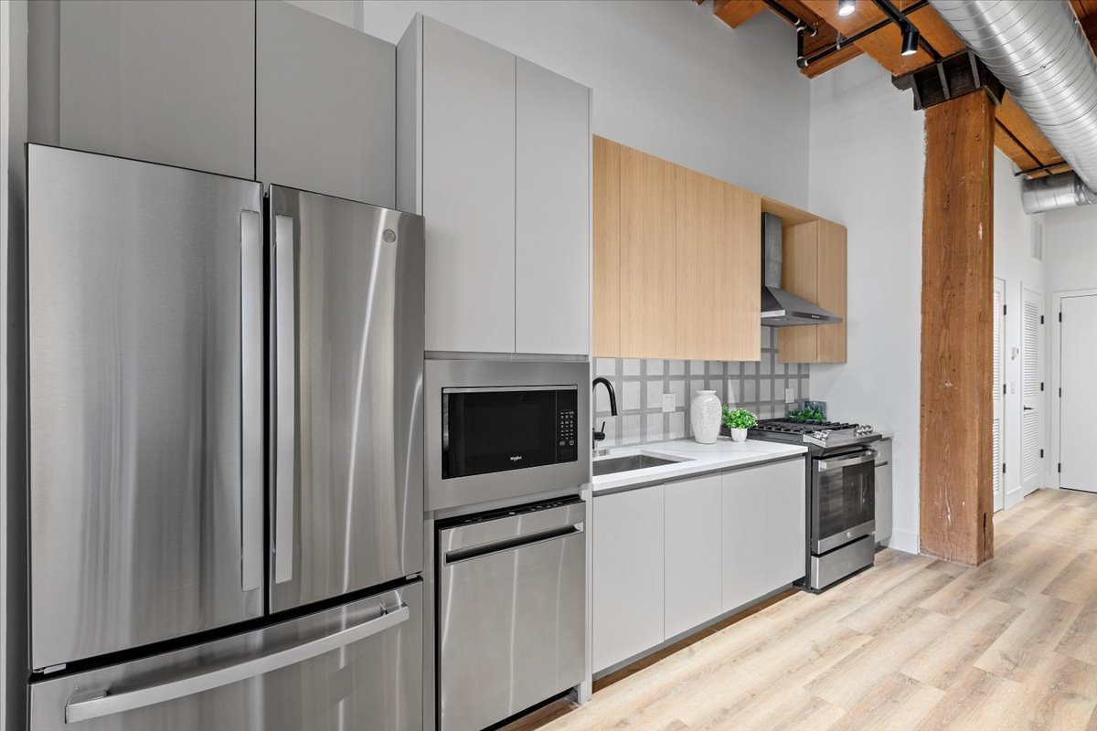 153 West Ohio Street, Unit 202 Chicago, IL 60654 - Photo 9 of 11 a kitchen with a sink stainless steel appliances a counter top space and cabinets
