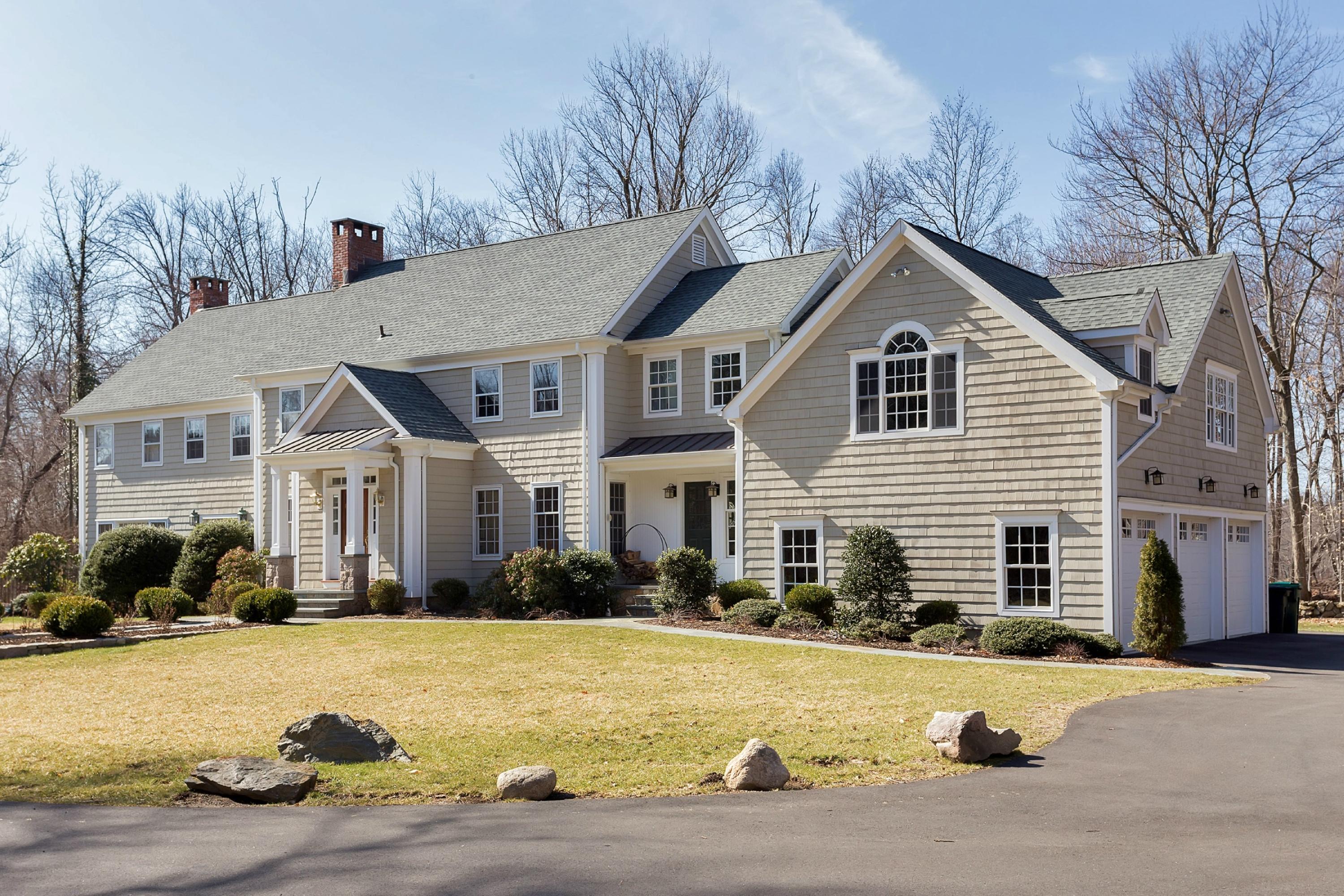 a front view of house with yard and trees in the background