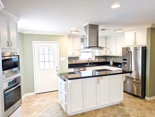 a kitchen with white cabinets and stainless steel appliances