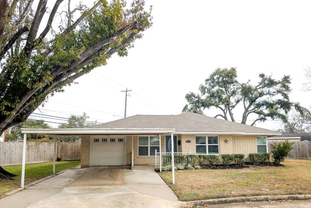 a front view of a house with a garden and trees