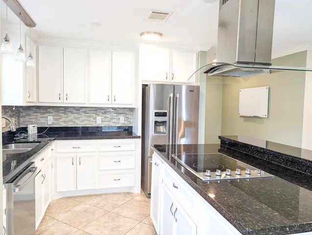 a kitchen with granite countertop a sink and a stove top oven