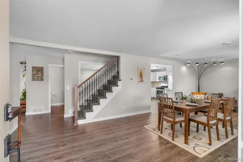 a dining room with furniture entryway and wooden floor