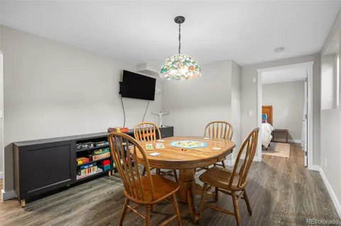 a dining room with furniture a chandelier and wooden floor