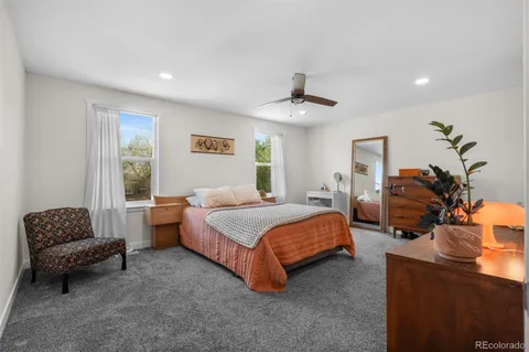 a bedroom with a bed couch chandelier and window