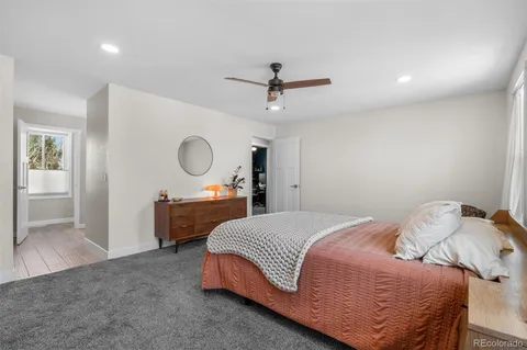 a bedroom with a bed a chandelier with a dresser and chandelier
