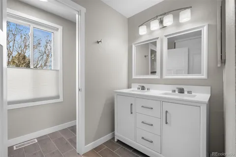 a bathroom with a double vanity sink and a mirror
