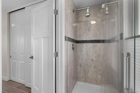 a bathroom with a glass shower door and a shower