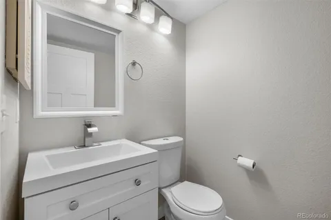 a bathroom with a sink a toilet and a mirror