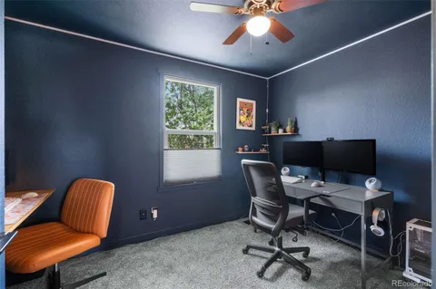 a view of a workspace with furniture and a window