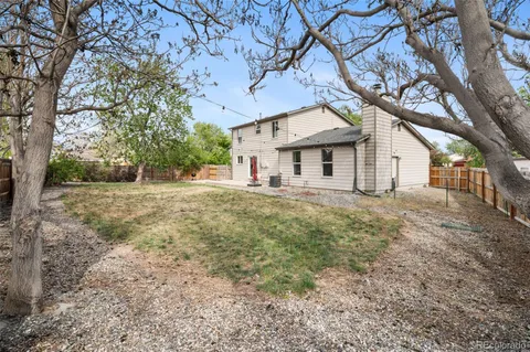 a front view of a house with a yard and large tree