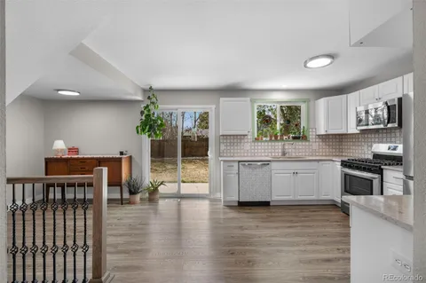 a kitchen with stainless steel appliances kitchen island granite countertop a stove a sink and a refrigerator