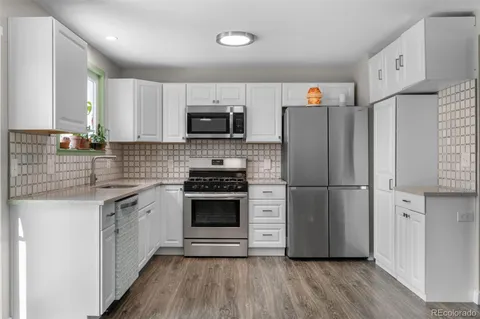 a kitchen with stainless steel appliances a refrigerator sink and microwave