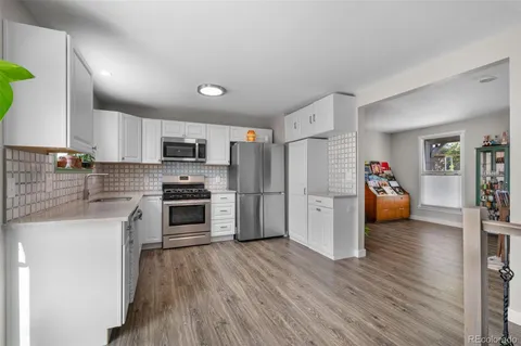 a kitchen with a refrigerator and a stove top oven