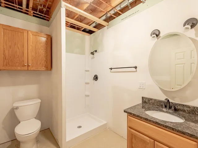 a bathroom with a granite countertop sink toilet and shower