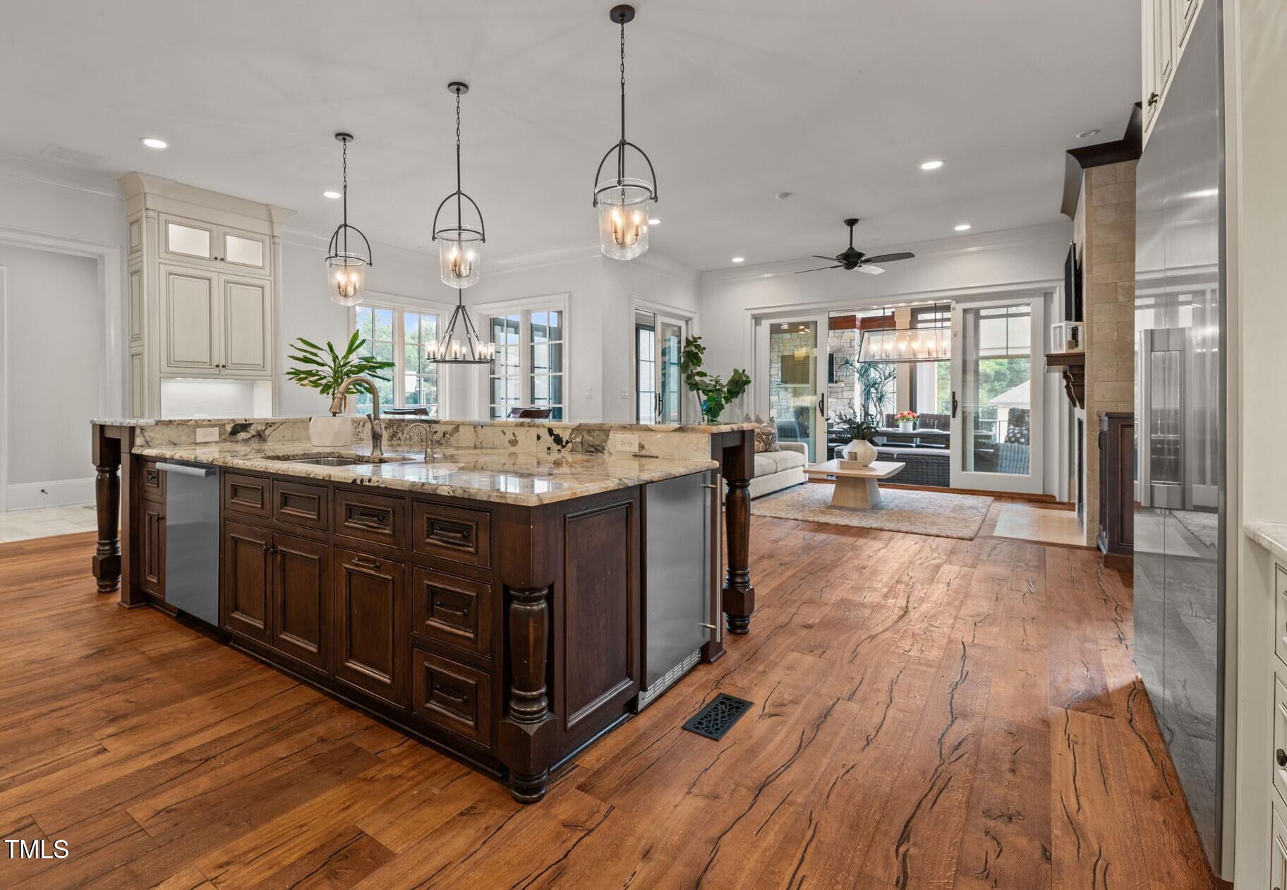 12660 Boyce Mill Road Raleigh, NC 27613 - Photo 16 of 89 a kitchen with kitchen island granite countertop wooden floors and a view of living room