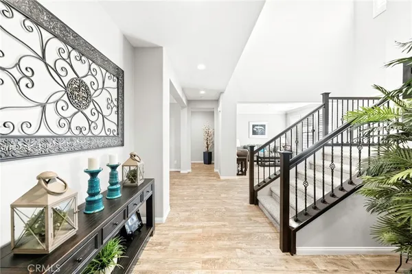a view of a hallway to an entryway with wooden floor
