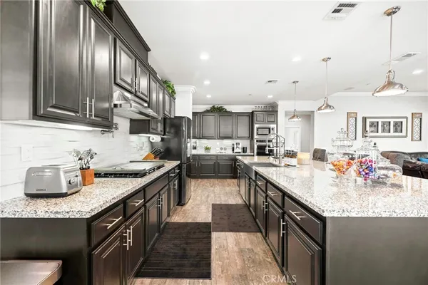 a kitchen with granite countertop a sink stove and cabinets