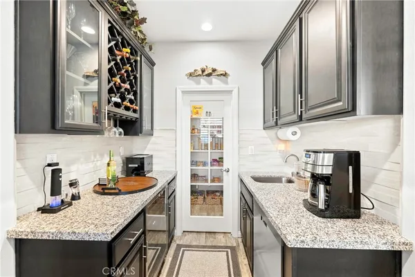 a kitchen with granite countertop kitchen island stainless steel appliances a sink stove and cabinets