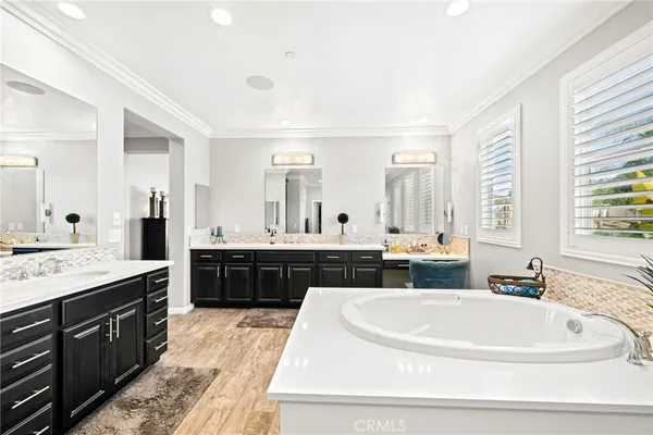 a large bathroom with a double vanity sink a bathtub a mirror and vanity