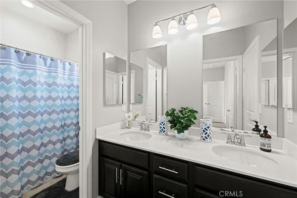 a bathroom with a double vanity sink mirror and toilet