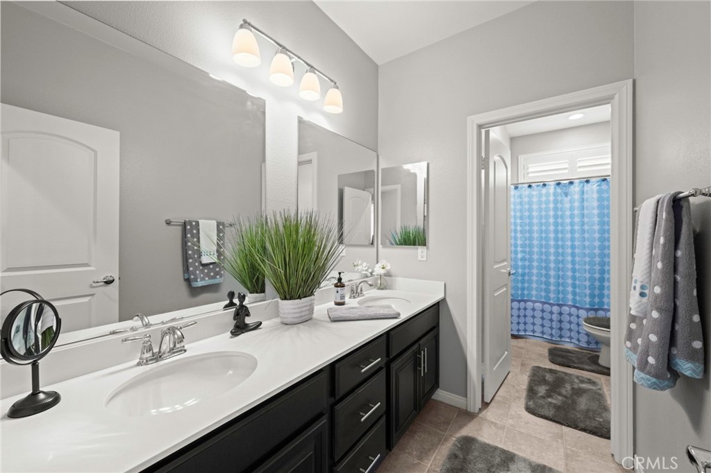 16555 Vía Los Caballeros Riverside, CA 92504 - Photo 31 of 51 a bathroom with a double vanity sink a double vanity and a mirror