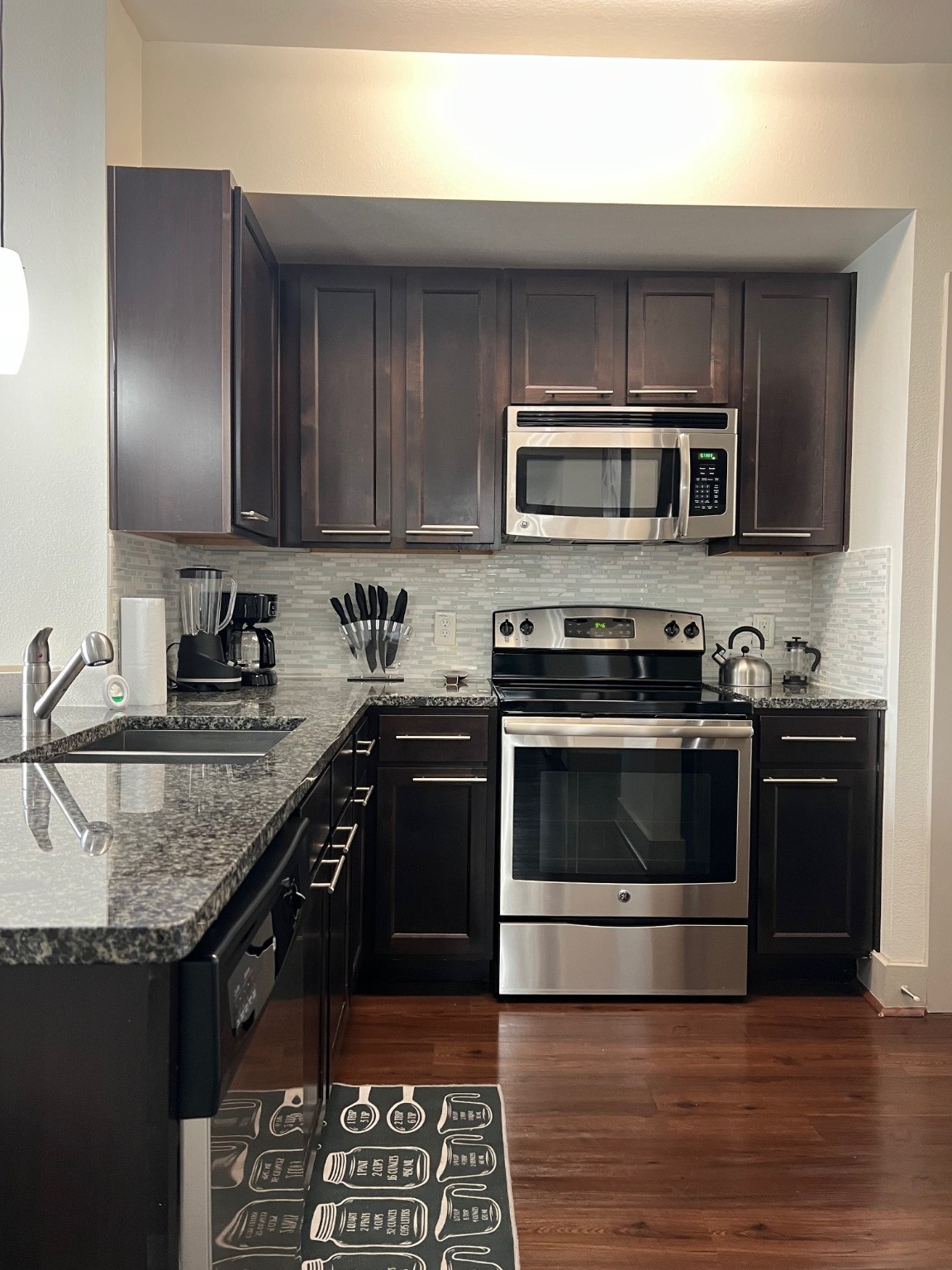 145 Heights Boulevard, Unit 363 Houston, TX 77007 - Photo 3 of 10 a kitchen with stainless steel appliances granite countertop a stove microwave and sink