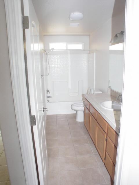 7764 Pit Road Redding, CA 96001 - Photo 6 of 8 a bathroom with a double vanity sink toilet and shower