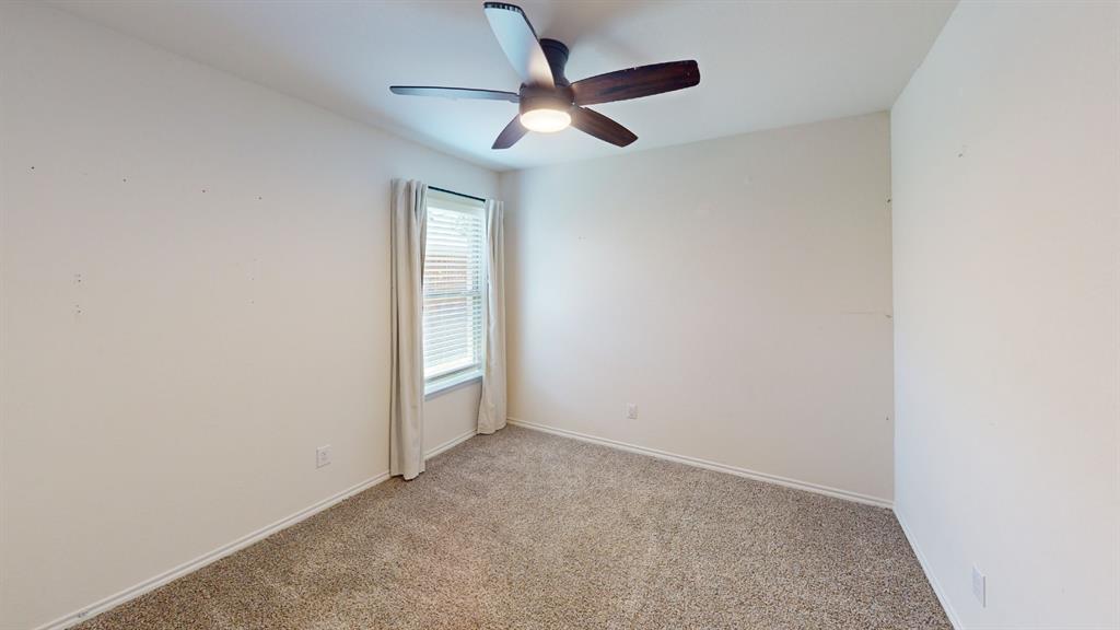 2210 Alamo Road Sherman, TX 75090 - Photo 11 of 17 Neutral-toned carpeting paired with white walls, a single window with blinds, and a ceiling fan with integrated lighting