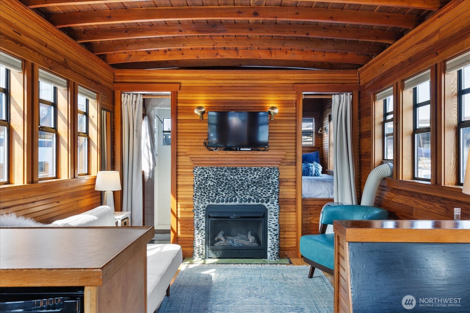 2401 North Northlake Way, Unit E7 Seattle, WA 98103 - Photo 4 of 23 a living room with a fireplace a flat screen tv and a chandelier